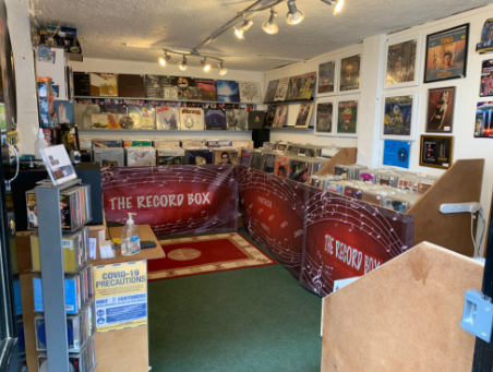 Looking down the aisle between two long record bins branded 'The Record Box'.